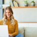 A smiling woman using a laptop.